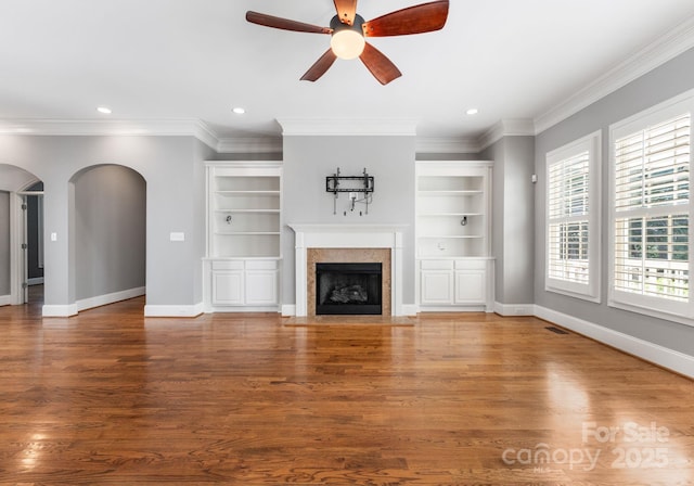 4536 Rustling Woods Dr, Denver, NC 28037 - unfurnished living room featuring arched walkways, a ceiling fan, ornamental molding, recessed lighting, and a fireplace with flush hearth