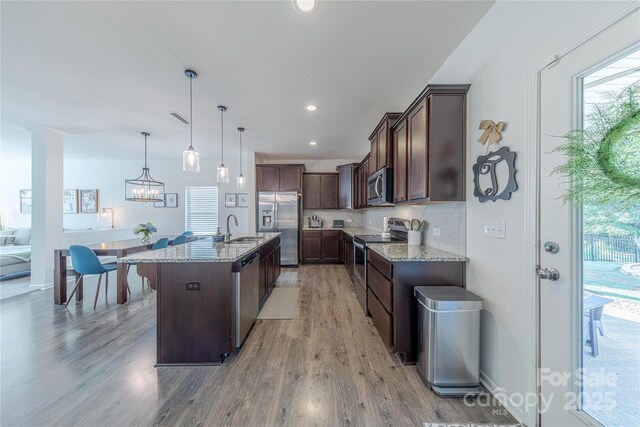 4113 Bent Green Ln, Monroe, NC 28112 - kitchen featuring stainless steel appliances, dark brown cabinets, light stone counters, light wood finished floors, and tasteful backsplash