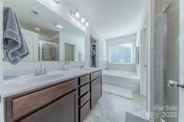 4113 Bent Green Ln, Monroe, NC 28112 - full bathroom featuring a shower stall, a bath, double vanity, a walk in closet, and stone finish floors