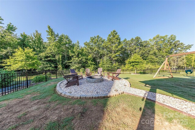 4113 Bent Green Ln, Monroe, NC 28112 - fenced backyard featuring an outdoor fire pit, a playground, and a patio area