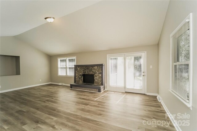4937 Post Oak Ln, Rock Hill, SC 29732 - unfurnished living room with lofted ceiling, wood finished floors, and a stone fireplace