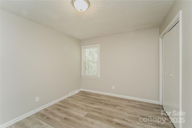 4937 Post Oak Ln, Rock Hill, SC 29732 - unfurnished bedroom featuring light wood finished floors, a textured ceiling, and a closet