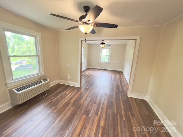 413 Forest Pl NW, Lenoir, NC 28645 - empty room with dark wood-style flooring, a ceiling fan, and a wall unit AC