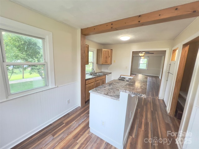 413 Forest Pl NW, Lenoir, NC 28645 - kitchen with brown cabinets, dark wood-style flooring, beam ceiling, a wainscoted wall, and a center island