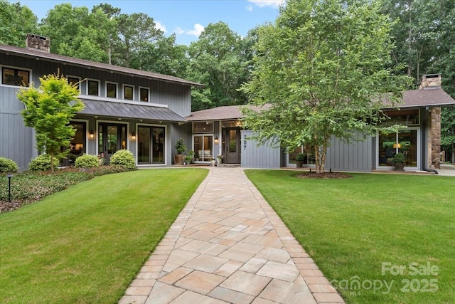 307 E Allenton St, Mount Gilead, NC 27306 - view of front of home featuring a chimney, a front yard, board and batten siding, and a standing seam roof