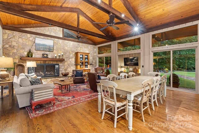 307 E Allenton St, Mount Gilead, NC 27306 - dining space featuring a wooden ceiling with exposed beams, high vaulted ceiling, a ceiling fan, wood finished floors, and a stone fireplace