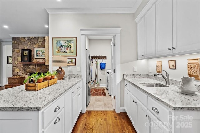 307 E Allenton St, Mount Gilead, NC 27306 - kitchen featuring washing machine and dryer, crown molding, freestanding refrigerator, a peninsula, and light stone countertops