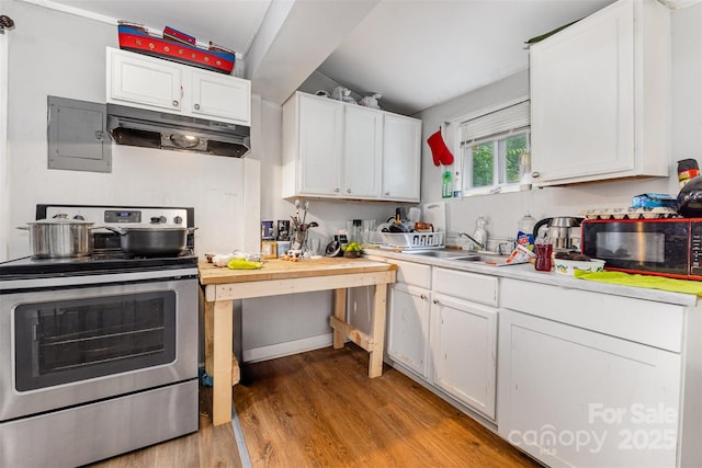 822 Cantwell St, Charlotte, NC 28208 - kitchen with stainless steel range with electric cooktop, under cabinet range hood, black microwave, electric panel, and light wood-style floors