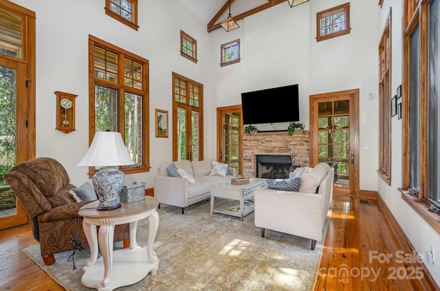 177 Yadkin Falls Rd, New London, NC 28127 - living area featuring a high ceiling, wood finished floors, and a stone fireplace