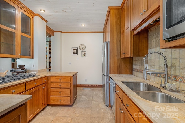 177 Yadkin Falls Rd, New London, NC 28127 - kitchen with appliances with stainless steel finishes, brown cabinetry, light countertops, backsplash, and ornamental molding