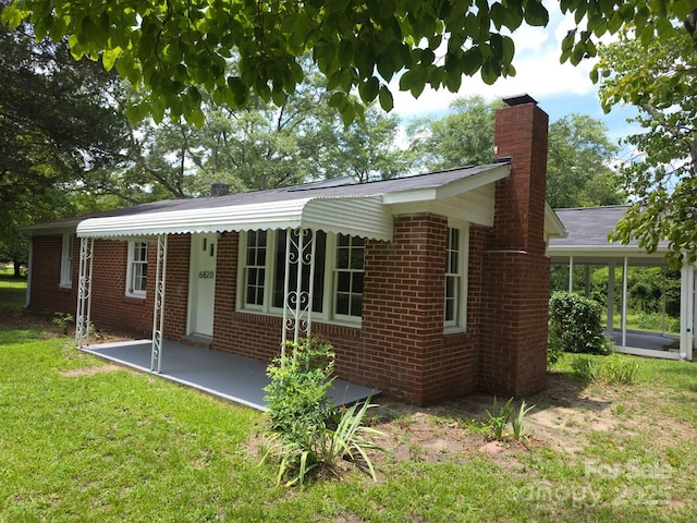 6820 Butterfly Ln, Kershaw, SC 29067 - view of front facade with a chimney, brick siding, and a front yard