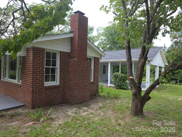 6820 Butterfly Ln, Kershaw, SC 29067 - view of side of property with brick siding, a chimney, and a sunroom
