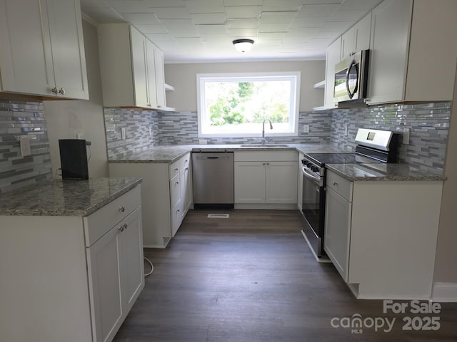 6820 Butterfly Ln, Kershaw, SC 29067 - kitchen with stainless steel appliances, open shelves, light stone counters, and backsplash