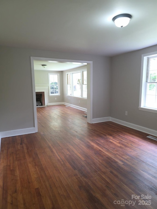 6820 Butterfly Ln, Kershaw, SC 29067 - spare room featuring dark wood-style floors and a fireplace