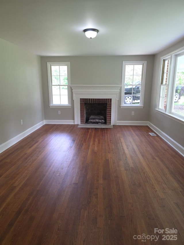 6820 Butterfly Ln, Kershaw, SC 29067 - unfurnished living room with a brick fireplace and dark wood-type flooring