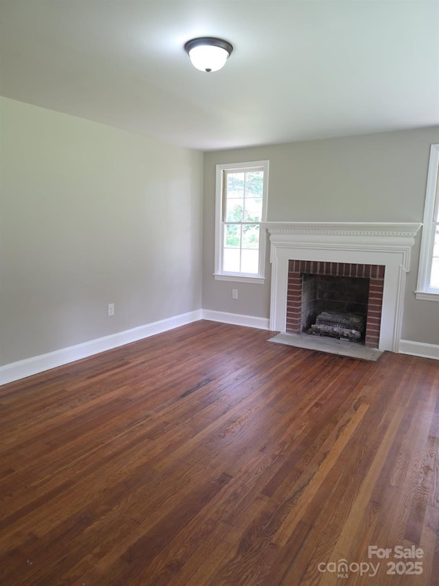 6820 Butterfly Ln, Kershaw, SC 29067 - unfurnished living room featuring healthy amount of natural light, dark wood-style flooring, and a brick fireplace