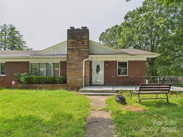 61 23rd St NW, Hickory, NC 28601 - view of front of home featuring board and batten siding, brick siding, a front lawn, and a chimney