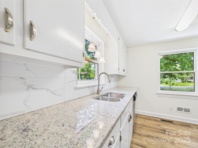 61 23rd St NW, Hickory, NC 28601 - kitchen with healthy amount of natural light, white cabinets, tasteful backsplash, and light wood-style flooring