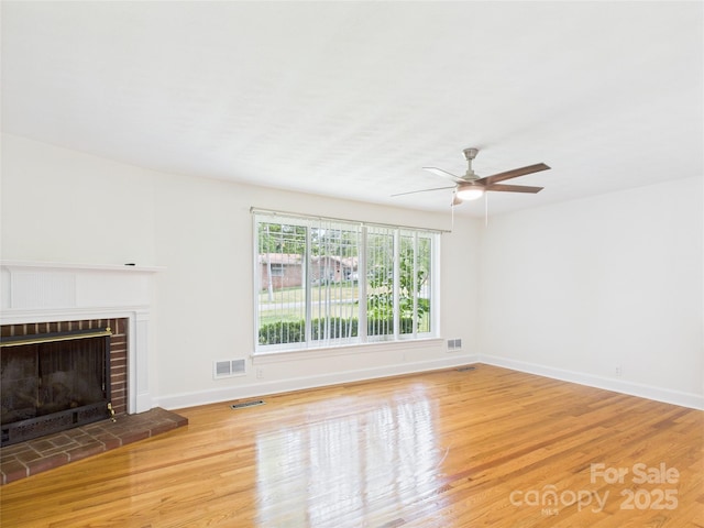61 23rd St NW, Hickory, NC 28601 - unfurnished living room with wood finished floors, a ceiling fan, and a brick fireplace