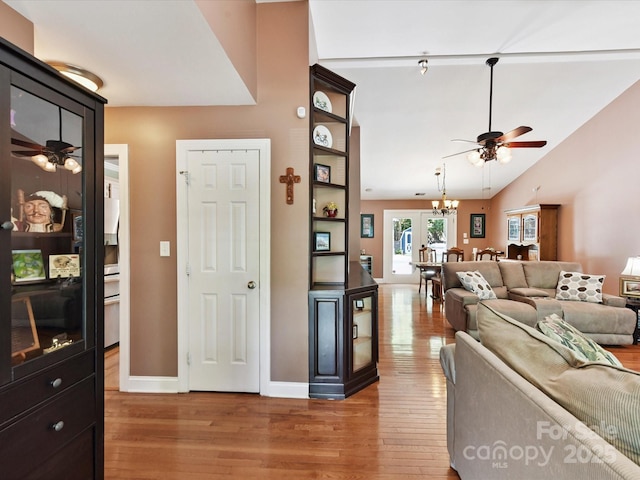 7139 Powder Mill Pl, Charlotte, NC 28277 - living room with a ceiling fan, light wood-style flooring, vaulted ceiling, and a chandelier