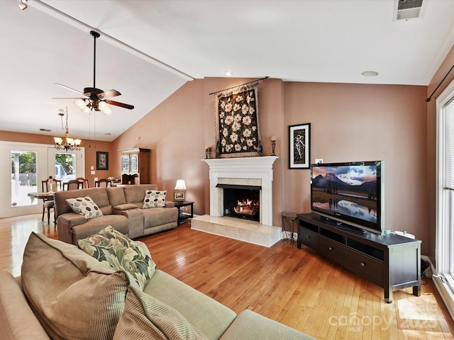 7139 Powder Mill Pl, Charlotte, NC 28277 - living area with light wood-style floors, ceiling fan, a lit fireplace, vaulted ceiling, and plenty of natural light