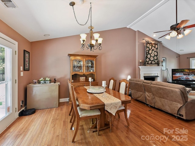 7139 Powder Mill Pl, Charlotte, NC 28277 - dining room with light wood finished floors, a chandelier, a fireplace, lofted ceiling, and ceiling fan