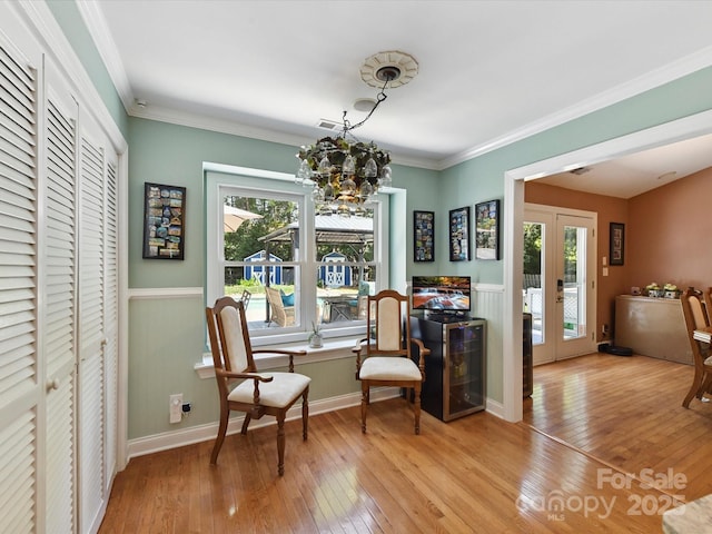 7139 Powder Mill Pl, Charlotte, NC 28277 - sitting room with light wood finished floors, a chandelier, french doors, ornamental molding, and a wainscoted wall