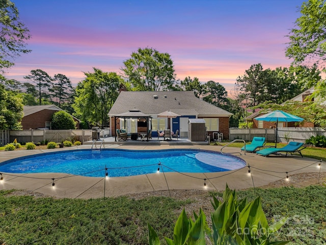7139 Powder Mill Pl, Charlotte, NC 28277 - pool at dusk with a gazebo, a fenced backyard, and a patio area