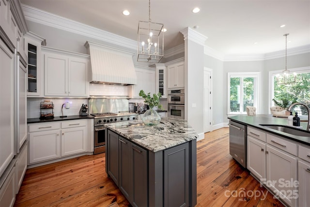 175 Rehoboth Ln, Mooresville, NC 28117 - kitchen featuring appliances with stainless steel finishes, premium range hood, a chandelier, tasteful backsplash, and a kitchen island