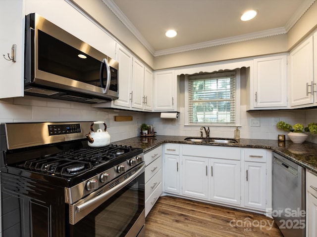 1708 Roxborough Rd Unit C, Charlotte, NC 28211 - kitchen featuring appliances with stainless steel finishes, crown molding, white cabinetry, dark stone countertops, and tasteful backsplash