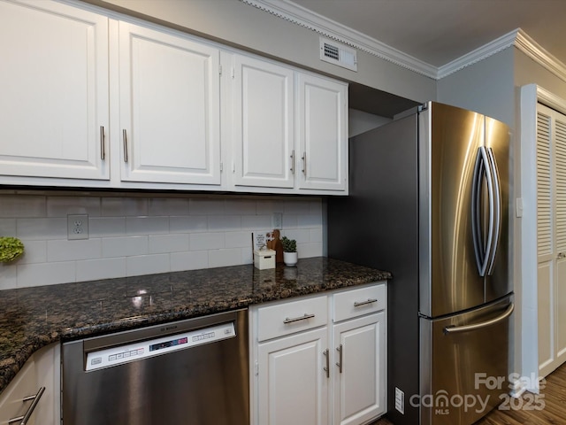 1708 Roxborough Rd Unit C, Charlotte, NC 28211 - kitchen with appliances with stainless steel finishes, white cabinets, crown molding, backsplash, and dark stone countertops