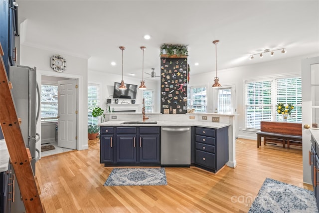 1069 Westlake Dr, Kannapolis, NC 28081 - kitchen with stainless steel appliances, ornamental molding, light wood-style flooring, blue cabinets, and plenty of natural light