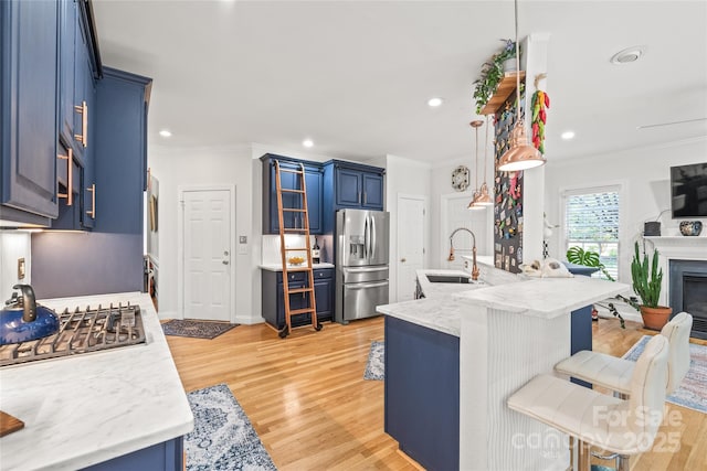 1069 Westlake Dr, Kannapolis, NC 28081 - kitchen with appliances with stainless steel finishes, blue cabinetry, a breakfast bar, crown molding, and light wood finished floors
