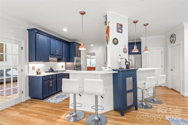 1069 Westlake Dr, Kannapolis, NC 28081 - kitchen with blue cabinetry, appliances with stainless steel finishes, a kitchen breakfast bar, light wood-style flooring, and crown molding