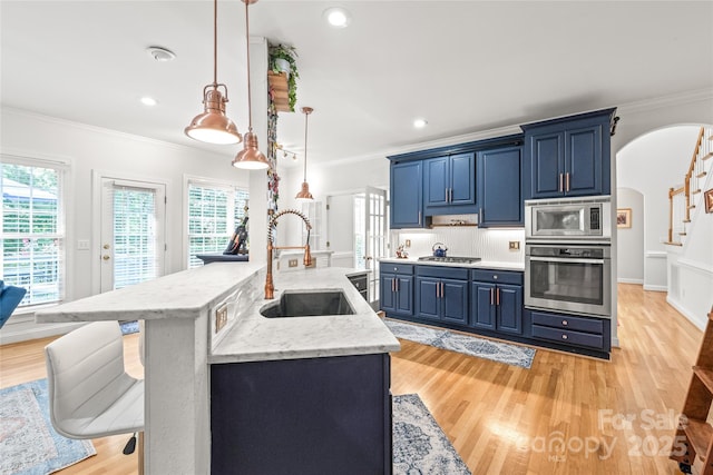 1069 Westlake Dr, Kannapolis, NC 28081 - kitchen with stainless steel appliances, blue cabinetry, arched walkways, crown molding, and healthy amount of natural light