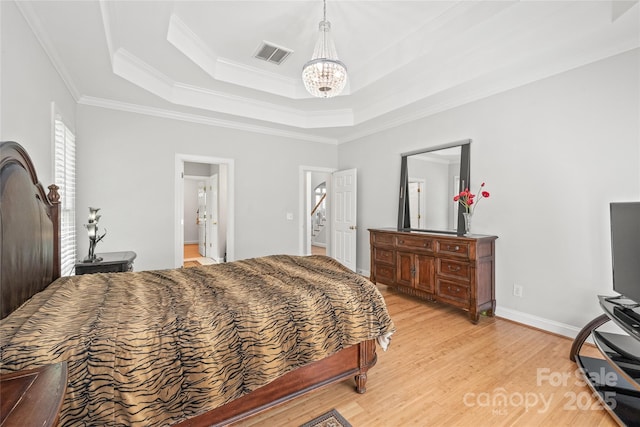 1069 Westlake Dr, Kannapolis, NC 28081 - bedroom featuring a tray ceiling, light wood finished floors, a chandelier, and crown molding