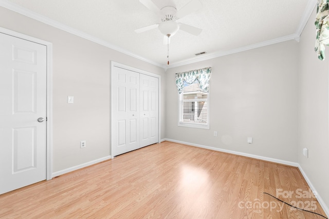 611 Church St, Belmont, NC 28012 - unfurnished bedroom featuring light wood finished floors, crown molding, a closet, and a ceiling fan
