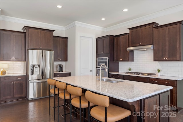 11806 Stirling Field Dr, Pineville, NC 28134 - kitchen with stainless steel appliances, under cabinet range hood, a kitchen bar, decorative backsplash, and dark wood-style flooring