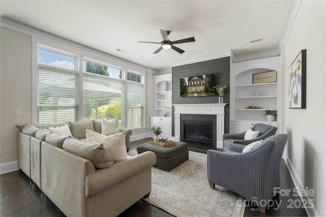 11806 Stirling Field Dr, Pineville, NC 28134 - living room featuring a ceiling fan, dark wood-type flooring, ornamental molding, a fireplace, and built in features