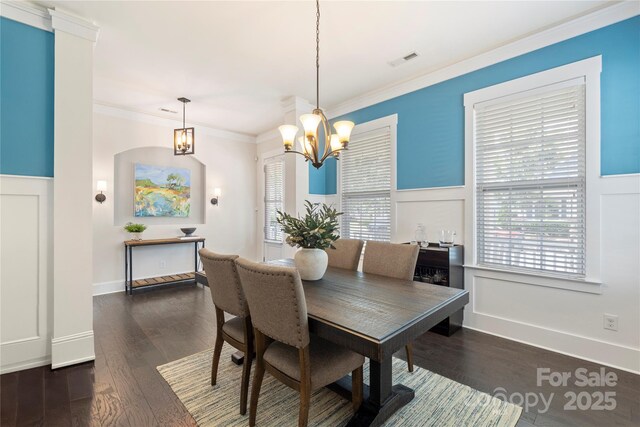 11806 Stirling Field Dr, Pineville, NC 28134 - dining space with a chandelier, a wainscoted wall, crown molding, a decorative wall, and dark wood-style flooring