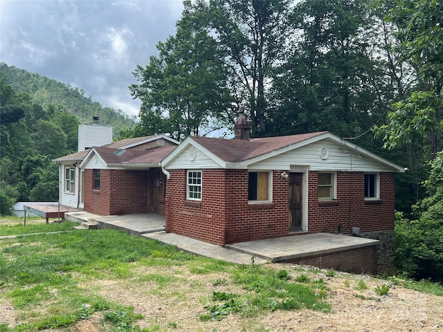 988 N Fork Rd, Barnardsville, NC 28709 - back of house featuring a chimney, brick siding, and a yard