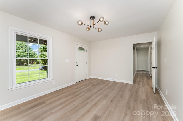 9410 Mountain Aire Cir, Charlotte, NC 28214 - spare room featuring a chandelier and light wood-type flooring