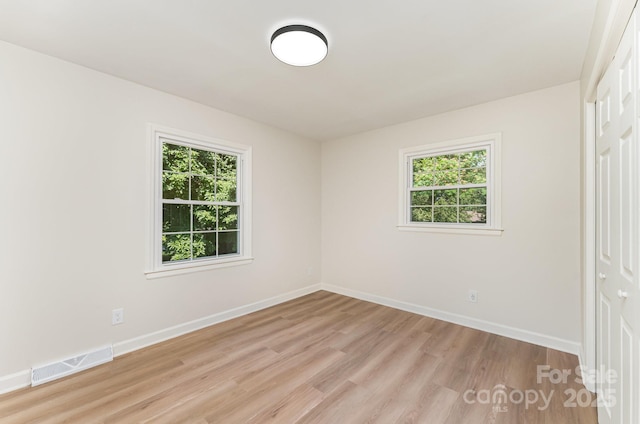 9410 Mountain Aire Cir, Charlotte, NC 28214 - unfurnished bedroom with multiple windows, light wood-type flooring, and a closet