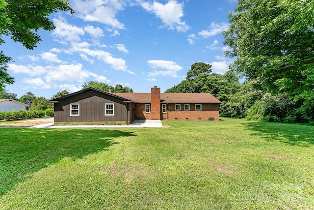 9410 Mountain Aire Cir, Charlotte, NC 28214 - rear view of property featuring a chimney, a yard, a patio area, brick siding, and crawl space