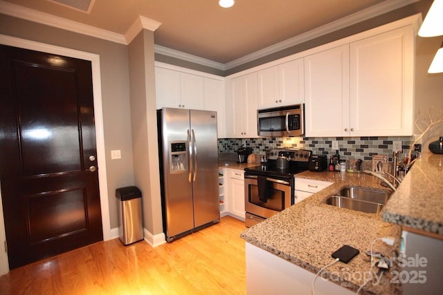 230 S Tryon St Unit 304, Charlotte, NC 28202 - kitchen featuring stainless steel appliances, light stone counters, light wood-type flooring, white cabinets, and tasteful backsplash