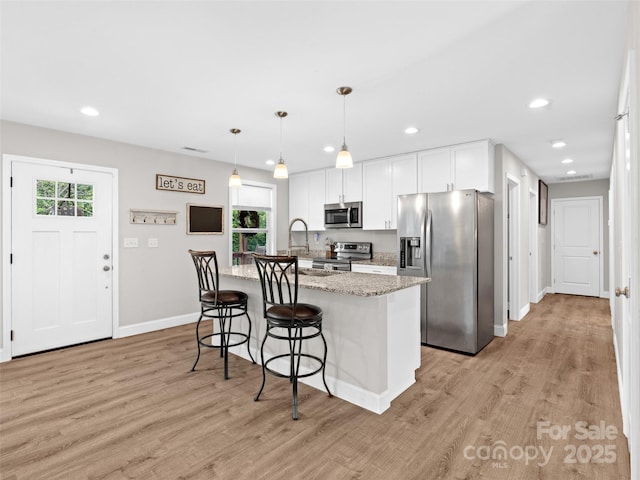 21 Brown Trout Trl, Candler, NC 28715 - kitchen featuring stainless steel appliances, healthy amount of natural light, light wood-style flooring, recessed lighting, and white cabinetry