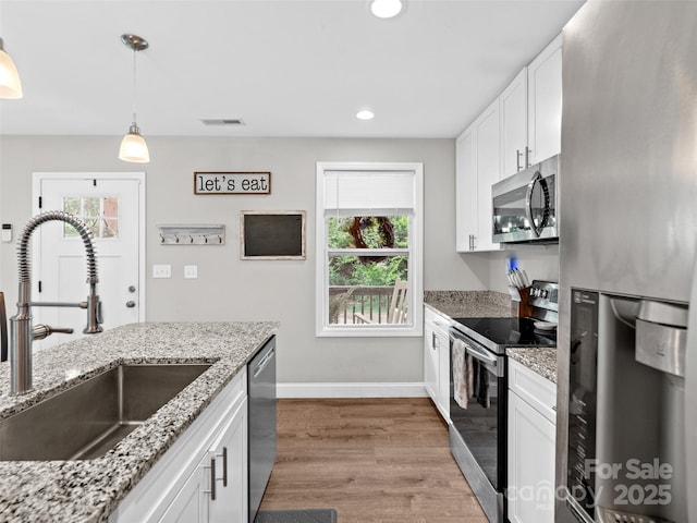 21 Brown Trout Trl, Candler, NC 28715 - kitchen with stainless steel appliances, plenty of natural light, white cabinets, wood finished floors, and recessed lighting
