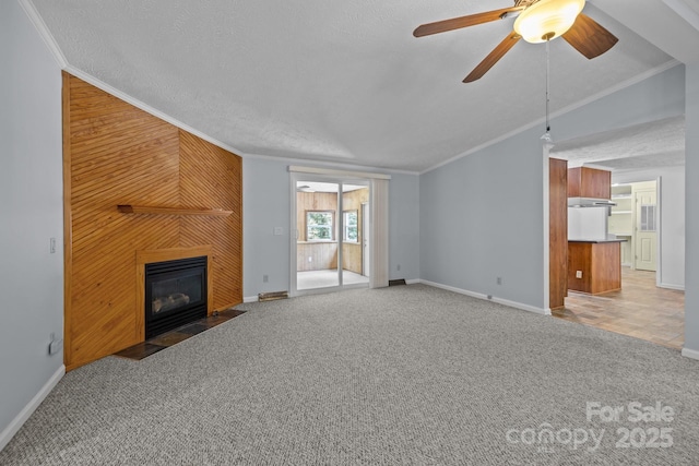 7011 S Providence Rd, Waxhaw, NC 28173 - unfurnished living room with crown molding, a fireplace, a ceiling fan, a textured ceiling, and light colored carpet