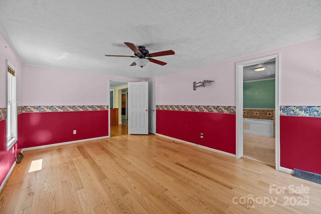 7011 S Providence Rd, Waxhaw, NC 28173 - empty room featuring wood finished floors, ceiling fan, a textured ceiling, and a wainscoted wall
