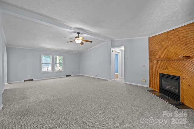 7011 S Providence Rd, Waxhaw, NC 28173 - unfurnished living room featuring a textured ceiling, a fireplace with flush hearth, ceiling fan, carpet, and crown molding